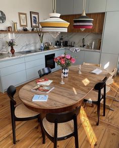 a wooden table with chairs around it in a kitchen