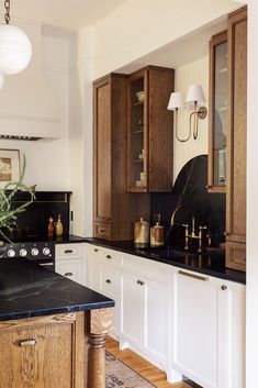 a kitchen with white cabinets and black counter tops