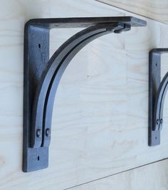 two metal brackets mounted to the side of a wooden wall