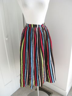 VINTAGE  50'S  RAYON   BLACK AND  MULTI COLOR  VERTICAL STRIPE   CIRCLE SKIRT. .    METAL SIDE ZIPPER AND  METAL HOOK WAIST CLOSURE  .  GATHERED BELOW THE WAIST   UNLINED. TAGS/LABELS: NONE - HOME MADE?  ESTIMATED SIZE:MEDIUM/LARGE  - SEE BELOW MEASUREMENTS CONDITION: EXCELLENT  VINTAGE. DOES HAVE A COUPLE LITTLE PIN HOLES IN THE WAIST BAND ( YOU CAN SEE IT IN THE SECOND PHOTO) MEASUREMENTS TAKEN LAYING FLAT WAIST:15"  HIPS: free  OVERALL LENGTH: 28" ( 1." hem) Retro Knee-length Gathered Skirt Bottoms, Vintage Gathered Skirt Bottoms For Summer, Retro Full Lined Skirt, Vintage Gathered Skirt For Summer, Vintage Multicolor Lined Bottoms, Skirt Vintage, Circle Skirt, Chicago Il, Full Skirt