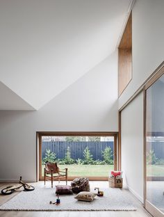 a living room filled with furniture and lots of windows next to a wooden floor covered in white rugs