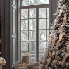 a decorated christmas tree in front of a window