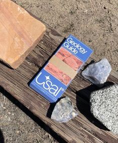 some rocks and a book on a wooden bench in the dirt with text that reads godly guide usa