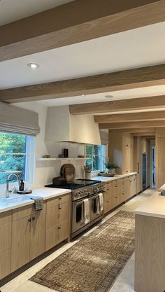 a large kitchen with an oven, sink and counter tops in front of a window