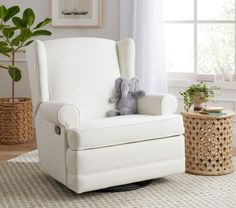 a white rocking chair with a stuffed elephant on it