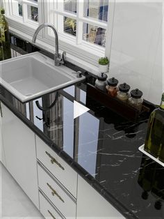 a kitchen with black marble counter tops and white cabinets