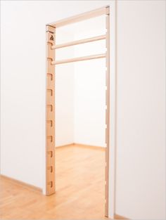 an open door in a white room with wooden flooring and hard wood planks