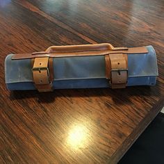 a blue and brown case sitting on top of a wooden table