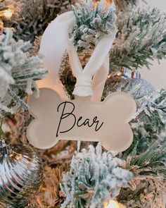 a dog bone ornament hanging on a christmas tree with the word bead