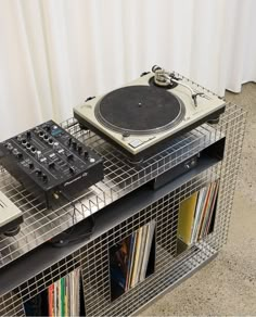 an old record player sitting on top of a metal shelf next to a cd player