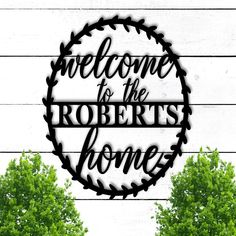 a metal sign that says welcome to the robert's home with trees in the background