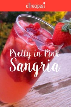 a drink with strawberries in it and the words pretty in pink sangria