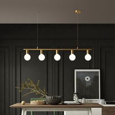 a dining room table with four lights hanging from the ceiling