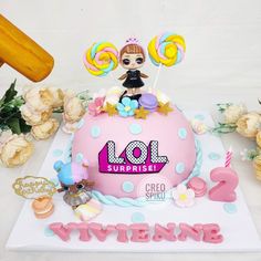 a birthday cake decorated with lol surprise candy, candies and other decorations on a table