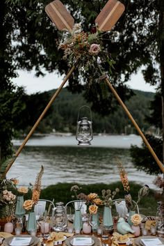 a table set up with plates and utensils for an outdoor dinner party by the water