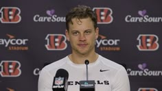 a man standing at a microphone in front of a wall with the words browns stadium on it