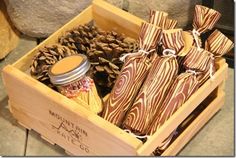 a wooden box filled with lots of different types of candy and pineconi cones