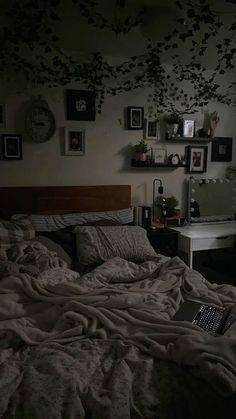 a laptop computer sitting on top of a bed in a room with many pictures above it