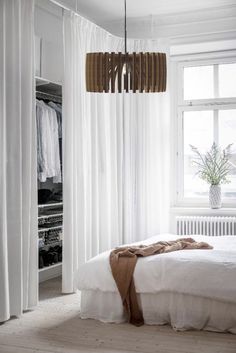 a bedroom with white curtains and a bed