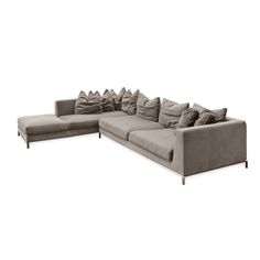 a large sectional couch with pillows on it's back and side facing each other