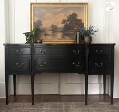 two black dressers in front of a painting on the wall