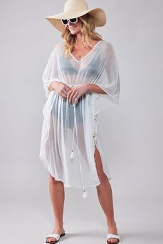 Complete your Summer and beach look with Urban Daizy's shimmer sheer poncho. Featuring kimono sleeves, v-neck line, and elastic waist with tassel tie, this one size cover up is perfect for lounging by the pool or wearing over your bathing suit. Made with 100% polyester, it's lightweight and easy to pack for all your warm weather vacations. Bohemian Sheer V-neck Cover-up, Lightweight Wrap Beach Cover-up, Lightweight V-neck Cover-up For Beachwear, Lightweight V-neck Beach Cover-up, Beachwear Cover-up Wrap For Loungewear, Beachwear Wrap Cover-up, White Sheer V-neck Cover-up, Summer Beach Cover-up With Drawstring, Vacation V-neck Kaftan With Tassel Ties