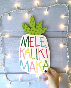 a hand holding up a sign that says mele kaliki maka