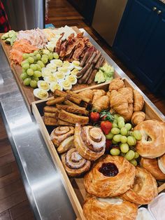 an assortment of breads, pastries and fruit are on display in a buffet