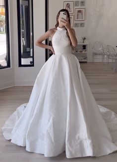 a woman in a white wedding dress taking a selfie