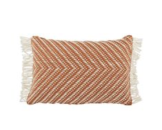 an orange and white pillow with fringes