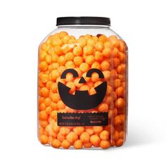 a glass jar filled with orange candy balls