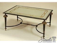 a glass and metal coffee table with gold trimmings on the top, sitting against a white background