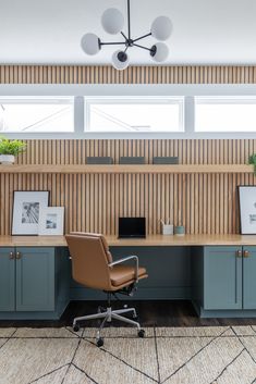 an office with blue cabinets and a brown chair in front of the desk is shown