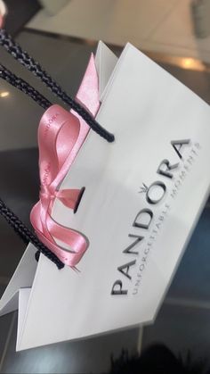 a paper bag with pink ribbon tied to it's side and the word pandadora written on it