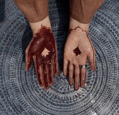 two hands with red and white designs on them