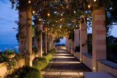 an outdoor walkway lit up with string lights