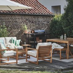 an outdoor patio with chairs, table and grill