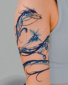 a woman's arm with blue flowers and swirls painted on the back of it