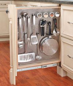 an open kitchen cabinet with utensils in it