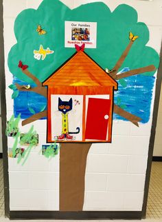 a classroom door decorated with an image of a tree house and a cat on it