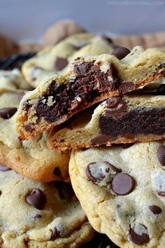 chocolate chip cookies stacked on top of each other with one broken cookie in the middle