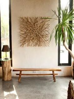 a wooden bench sitting in front of a window next to a potted palm tree