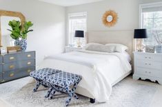 a bedroom with a bed, dressers and mirror in it's center area