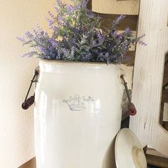 a white vase sitting on top of a wooden table