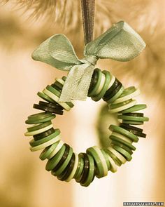 a green wreath ornament hanging from a christmas tree with a bow on it