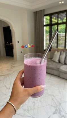 a person holding a glass with a smoothie in it