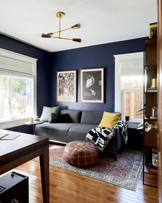 a living room with blue walls and wooden floors is pictured in this image, there are pictures on the wall