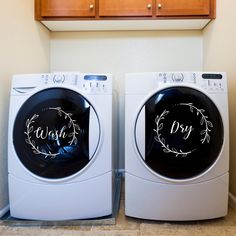 two washer dryers sitting side by side next to each other