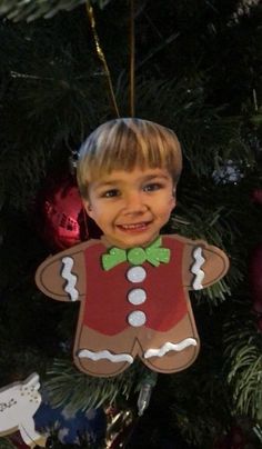 a child's ornament hanging from a christmas tree