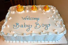 a welcome baby boy cake with rubber ducks on it